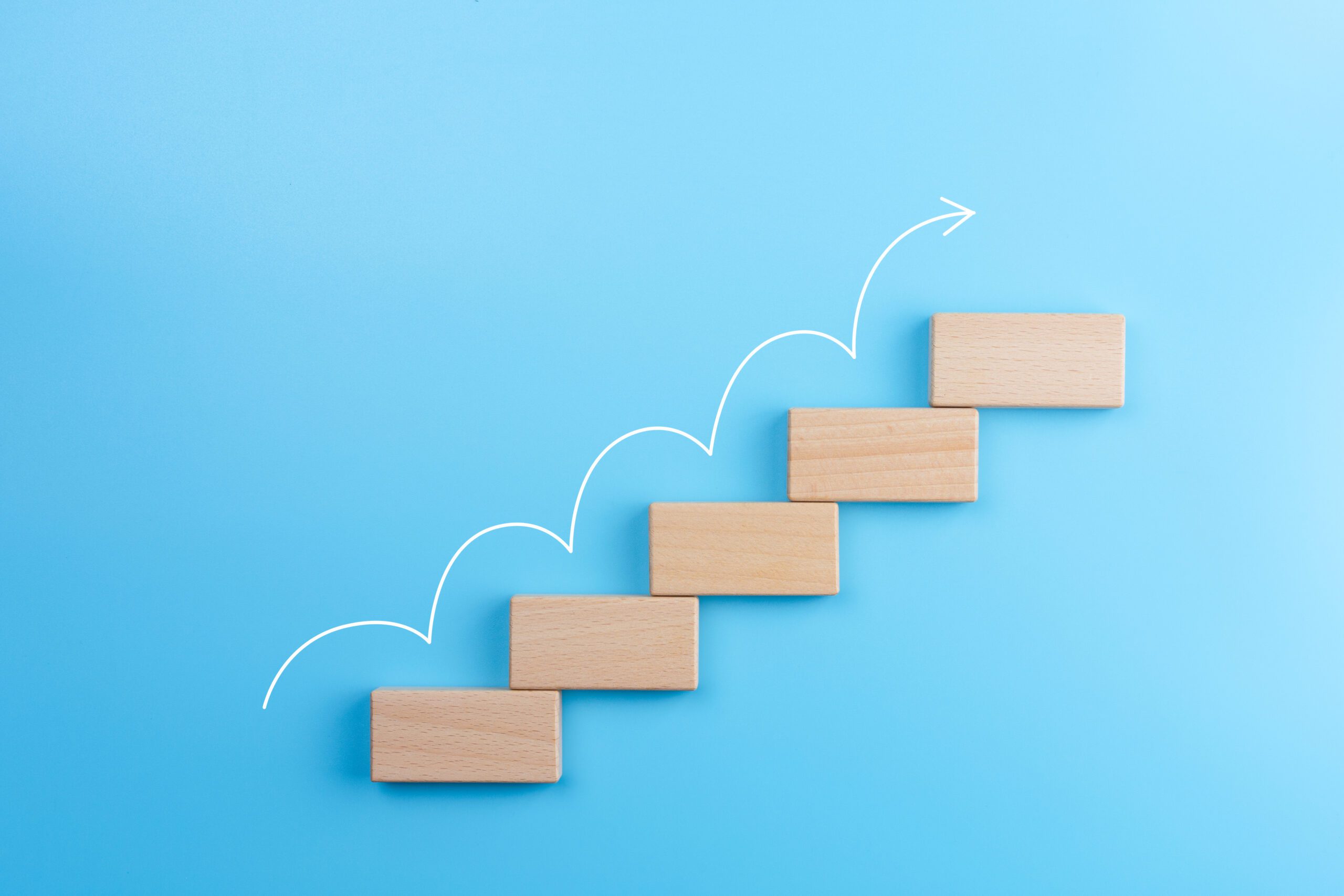 Wooden Block Stacking As Step Stair With White Arrow Up On Blue